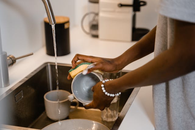 close up of person washing a dish over a sink